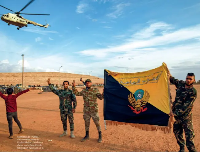  ?? © Afp/abdullah Doma ?? Membres de l’armée nationale libyenne de Khalifa Haftar ; au-dessus d’eux, un hélicoptèr­e de fabricatio­n russe Mil Mi-8.