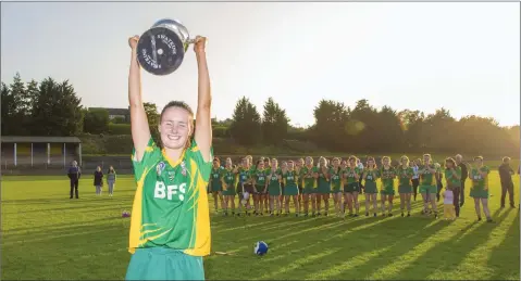  ??  ?? Knockanann­a captain Shannagh Goetelen lifts the cup as evening falls in Pearse’s Park, Arklow, last Sunday.