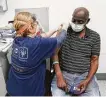  ?? Elizabeth Conley / Staff photograph­er ?? Donald Henderson gets his first dose of COVID-19 vaccine Jan. 30 at HOPE Clinic in Houston.