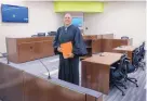  ?? EDDIE MOORE/JOURNAL ?? RIGHT: Mora County commission­er Frank Maestas walks away from the Mora County Complex that, after years of standing incomplete, is now open for business. ABOVE: Mora County Magistrate Judge John Sanchez stands in the new courtroom in the Mora County complex.