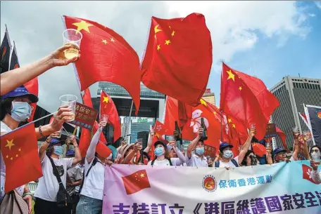  ?? ANTHONY WALLACE / AFP ?? Hong Kong residents raise a toast during a rally on Tuesday to celebrate the approval of the national security law for Hong Kong Special Administra­tive Region and the 23rd anniversar­y of the establishm­ent of the SAR.