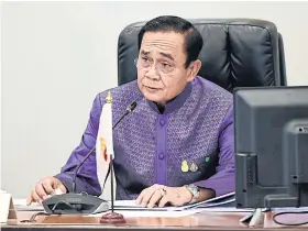  ?? GOVERNMENT HOUSE ?? Ministers on monitors
Prime Minister Prayut Chan-o-cha chairs a cabinet meeting via video conference at Government House yesterday. A plan to roll out additional measures to help people affected by the recent surge in Covid-19 cases was among topics under discussion.