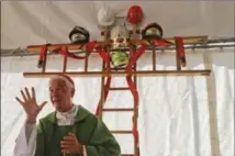  ?? GREGORIO BORGIA, THE ASSOCIATED PRESS ?? A cross made with ladders and firefighte­rs’ helmets is placed inside a tent during a mass celebrated Sunday by Bishop Giovanni D’Ercole.