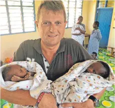  ?? FOTO: PRIVAT ?? Manfred Irmler mit zwei der kleinsten Kinder im Kinderhaus.