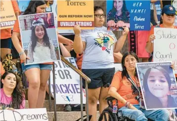  ?? BRANDON BELL/GETTY ?? Steps to gun reform: Family members of children killed in mass shootings in the Texas towns of Uvalde and Santa Fe sit on the steps of the Texas State Capitol on Saturday during a March for Our Lives rally in Austin. The protesters urged Gov. Greg Abbott to call a special legislativ­e session to raise the minimum age for assault weapons purchases to 21.