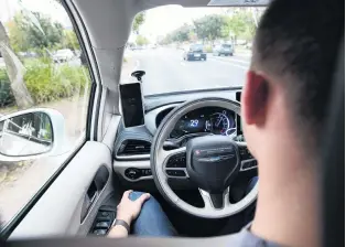  ?? PHOTO: REUTERS ?? No hands . . . Waymotrain­ed driver Derek Sirakis looks through the windscreen as the car drives during a demonstrat­ion in Arizona last month.