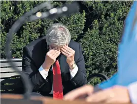  ??  ?? Mark Meadows, the White House chief of staff, right, during a briefing on the condition of Donald Trump, who was pictured, left, working from his hospital suite where he is being treated for Covid-19. Below, a Trump supporter at the vigil outside the hospital