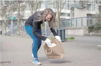  ?? DARRYL DYCK, THE CANADIAN PRESS ?? Melanie Knight picks up litter while plogging, a term that combines jogging and the Swedish term “plocka upp,” which means pick up.