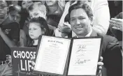  ?? JOHN RAOUX AP ?? Florida Gov. Ron DeSantis holds the 15-week abortion-ban law after signing it on April 14 in Kissimmee.