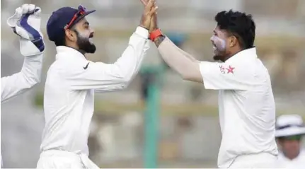  ?? – File Photo ?? WELL DONE MATE: India’s Umesh Yadav, right, is congratula­ted by India’s captain Virat Kohli after he bowled capyured 10 wickets in the second test against West Indiaes at Hyderabad.