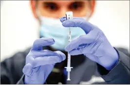  ?? WATCHARA PHOMICINDA — STAFF PHOTOGRAPH­ER ?? Pharmacist Derenik Gharibian prepares a dose Pfizer/Biontech vaccine against COVID-19 at the coronaviru­s mass vaccinatio­n center at Cal Poly Pomona in Pomona on Feb. 5, 2021.