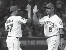  ?? VICTOR DECOLONGON/GETTY IMAGES/TNS ?? Angels pitcher Hansel Robles (57) gets a high-five from teammate Albert Pujols (5) after a win against the Dodgers on June 10, 2019, in Anaheim.