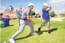  ?? ADOLPHE PIERRE-LOUIS/JOURNAL ?? Golf pro Nick Knee, left, shown working with 8-year-old Mason Hoefel at Sandia, will run in the New York City Marathon in November to raise money for junior golf through the PGA Reach program.