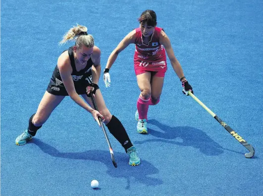  ?? PHOTO: GETTY IMAGES ?? Out of the blue . . . Black Sticks defender Liz Thompson (left) shields the ball from Japan’s Minami Shimuzi during their pool D game at the Women’s World Cup in London yesterday. Japan won 21.