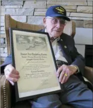  ?? JOHN SEEWER — THE ASSOCIATED PRESS ?? World War II veteran Bob Barger poses with his Naval flight school certificat­e in Toledo, Ohio.