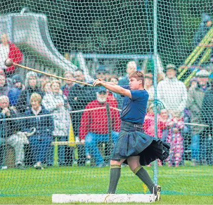  ?? Picture: Steve MacDougall ?? The hammer is launched on its way as the large Pitlochry crowd look on.