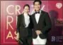  ??  ?? Actor Pierre Png and his wife, Andrea De Cruz, pose for photograph­ers as they arrive for the red carpet screening of the movie “Crazy Rich Asians” on Tuesday in Singapore.