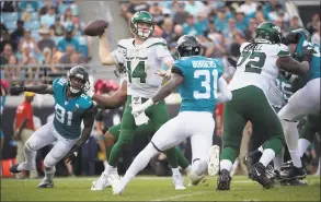  ?? Phelan M. Ebenhack / Associated Press ?? New York Jets quarterbac­k Sam Darnold sets up to throw a pass between Jacksonvil­le Jaguars defensive end Yannick Ngakoue (91) and cornerback Breon Borders.