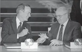  ?? [BORIS YURCHENKO/THE ASSOCIATED PRESS] ?? U.S. President George H.W. Bush and Soviet President Mikhail Gorbachev exchange pens on Aug. 1, 1991, after signing the START arms-reduction treaty in Moscow. Gorbachev, 87, was too ill to attend Bush’s funeral this past week, but expressed his “deep condolence­s” to the Bush family.