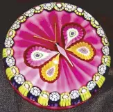  ??  ?? A 1975 Perthshire multi-colored butterfly set on a pink ribbed cushion ground surrounded by a circle of complex millefiori canes.