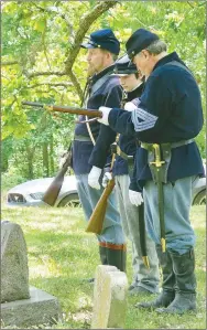  ?? Westside Eagle Observer/SUSAN HOLLAND ?? Riflemen Jim Spillars (left), and his son Jacob Spillars, 17, wait for fellow camp member Bob Underdown to finish loading his rifle just before firing a memorial volley at Monday’s Memorial Day service. The men are members of McPherson Camp #1, Sons of Union Veterans of the Civil War. Underdown is the camp communicat­ions officer.