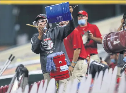  ?? AARON DOSTER — THE ASSOCIATED PRESS ?? Members of the Cincinnati Reds’ grounds crew acknowledg­e Reds’ Trevor Bauer as he stands in the dugout in the ninth inning during the team’s 6-1 win over the Milwaukee Brewers on Wednesday night in Cincinnati.