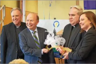  ?? MARIAN DENNIS – DIGITAL FIRST MEDIA ?? Jerry Parsons and Monsignor Joseph Marino hand the key to the school to Rev. Joseph Maloney and Sarah Kerins. The Foundation for Catholic Education recently purchased the former Saint Pius X High School building located on North Keim Street in Lower...