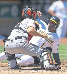  ?? BEN MARGOT — THE ASSOCIATED PRESS ?? The A’s Franklin Barreto is tagged out at home plate by Giants catcher Nick Hundley in Oakland’s thrilling 6-5 win Sunday at the Coliseum.