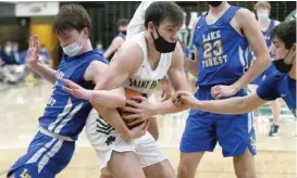  ?? ALLEN CUNNINGHAM/SUN-TIMES ?? St. Patrick’s Michael Hamilton (center) battles Lake Forest’s Tommy Aberle (left) for a rebound on Saturday.