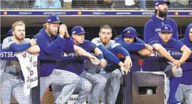  ?? GETTY ?? Stunned Dodgers watch from dugout as Padres record final outs of Saturday’s NLDS upset.