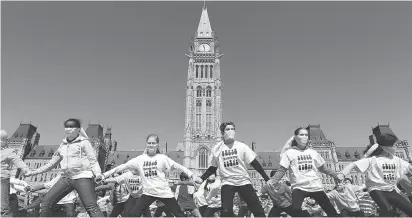  ?? JULIE OLIVER ?? Children dance at Parliament Hill for the Day of Pink. The April 11 event began in Nova Scotia after pupils saw a gay student in a pink shirt being bullied. They intervened and got others to wear pink shirts in a stand against homophobic and...