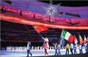  ?? PHOTOS PROVIDED TO CHINA DAILY ?? Xu Mengtao waves the Chinese flag as she is carried by fellow Team China gold medal winner Gao Tingyu, as they lead world athletes into the National Stadium on Feb 20.