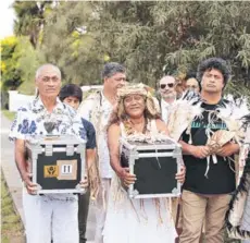  ??  ?? ► Isleños cargando las cajas contenedor­as de los vestigios arqueológi­cos.