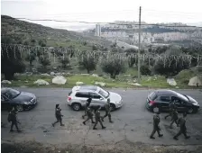  ?? Reuters ?? Israeli soldiers escort the convoy of the acting Latin Patriarch of Jerusalem as it passes the Har Homa settlement