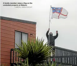  ?? CHRISTEL YARDLEY/STUFF ?? A family member raises a flag on the contested property at Maketu.