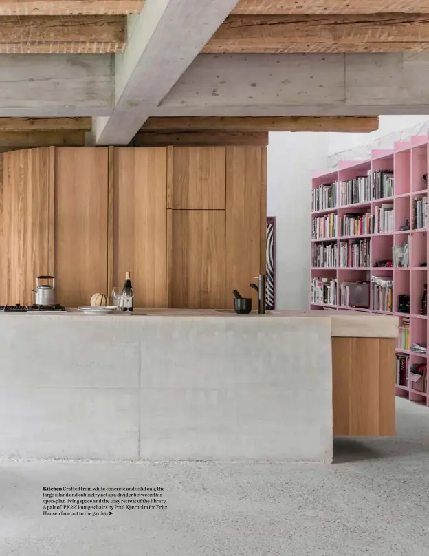  ??  ?? Kitchen Crafted from white concrete and solid oak, the large island and cabinetry act as a divider between this open-plan living space and the cosy retreat of the library. A pair of ‘PK22’ lounge chairs by Poul Kjærholm for Fritz Hansen face out to the garden ➤