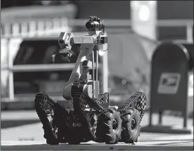  ?? AP/DAVID GOLDMAN ?? A robot exits a U.S. post office facility Monday as law enforcemen­t officials investigat­e a report that a suspicious package was found in Atlanta.