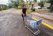  ?? GERALD HERBERT/ASSOCIATED PRESS ?? Fanchiskia Gulley is seen taking provisions back to her apartment on Friday after stocking up in the aftermath of Hurrican Sally.