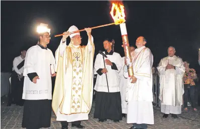  ?? ?? Monseñor Ricardo Valenzuela enciende el cirio pascual de la fogata bendecida. Fue al inicio de la Vigilia Pascual en Caacupé.