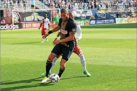  ?? FOR DIGITAL FIRST MEDIA — MIKE REEVES ?? Union defender Oguchi Onyewu holds off New England forward Teal Bunbury on Sunday during the Union’s 3-0 win.