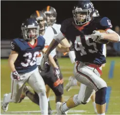  ?? HERALD PHOTOS BY JIM MICHAUD ?? ANOTHER ‘W’ FOR WARRIORS: Kyle Smith heads to the end zone for a touchdown as Lincoln-Sudbury gave coach Tom Lopez his 300th career victory last night, beating Wayland, 41-9; below, Smith drags down Wayland’s Michael Lampert.
