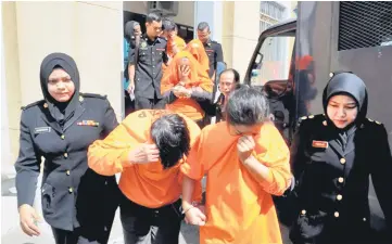  ??  ?? Some of the ten individual­s including seven doctors being brought to court for the remand hearing. — Bernama photo