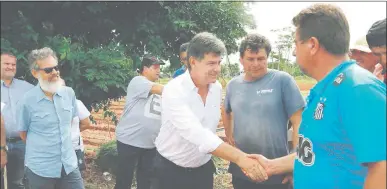  ??  ?? Efraín Alegre (camisa blanca) saluda a productore­s frutihortí­colas de J., Augusto Saldívar, departamen­to Central, ayer a la mañana. En su recorrida por la zona el presidenci­able liberal escuchó varios reclamos.