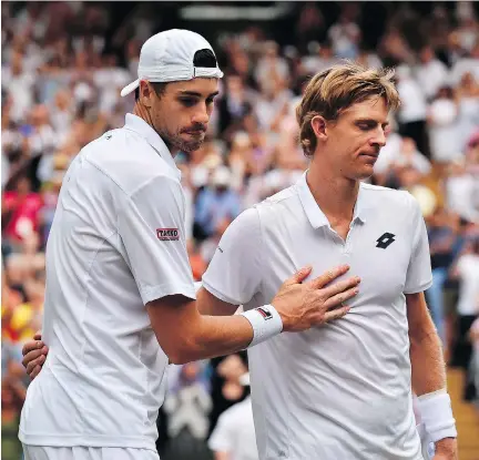  ?? GLYN KIRK/THE ASSOCIATED PRESS ?? American John Isner, left, meets up with Kevin Anderson of South Africa at the net following their epic five-set semifinal match on Friday at Wimbledon. Anderson prevailed in what is now the second-longest match in the history of a tournament that...