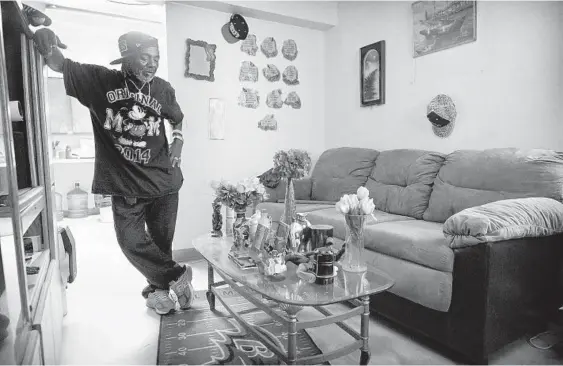  ?? KARL MERTON FERRON/BALTIMORE SUN ?? Charles Thomas, standing in the living room of his ground floor apartment at Gilmor Homes, cites issues with heating and vermin at the West Baltimore housing complex.