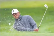  ??  ?? Tiger Woods plays a bunker shot during practice on Tuesday.