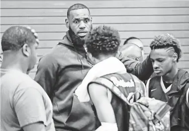  ?? PHOTOS BY JOSHUA KOMER/ MARS REEL/ USA TODAY NETWORK ?? LeBron James talks to his son, LeBron Jr., after a North Coast Blue Chips win last week.