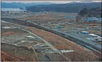  ?? (File Photo/AP/David Guttenfeld­er) ?? Vehicles pass in February 2012 through the ruins of the leveled city of Minamisanr­iku, almost one year after the tsunami.