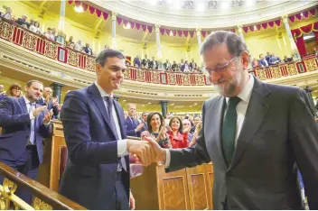  ?? — Reuters ?? Spain’s new Prime Minister and Socialist party (PSOE) leader Pedro Sanchez shakes hands with ousted prime minister Mariano Rajoy after a motion of no-confidence vote at parliament in Madrid on Friday.