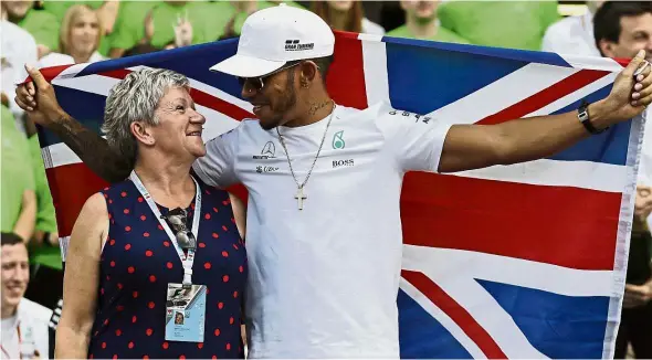  ??  ?? I did it mum: Mercedes driver Lewis Hamilton of Britain celebratin­g with his mother Carmen Larbalesti­er after winning the world title on Sunday. — AP